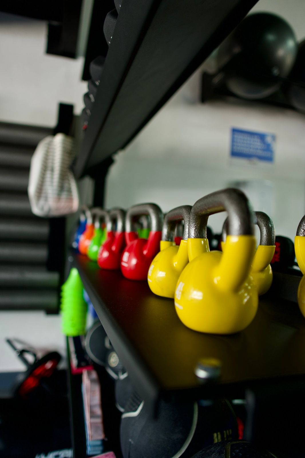 Kettlebells de colores en repisa